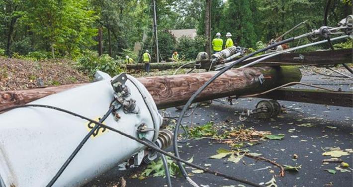 broken pole with transformer and fallen wires on ground